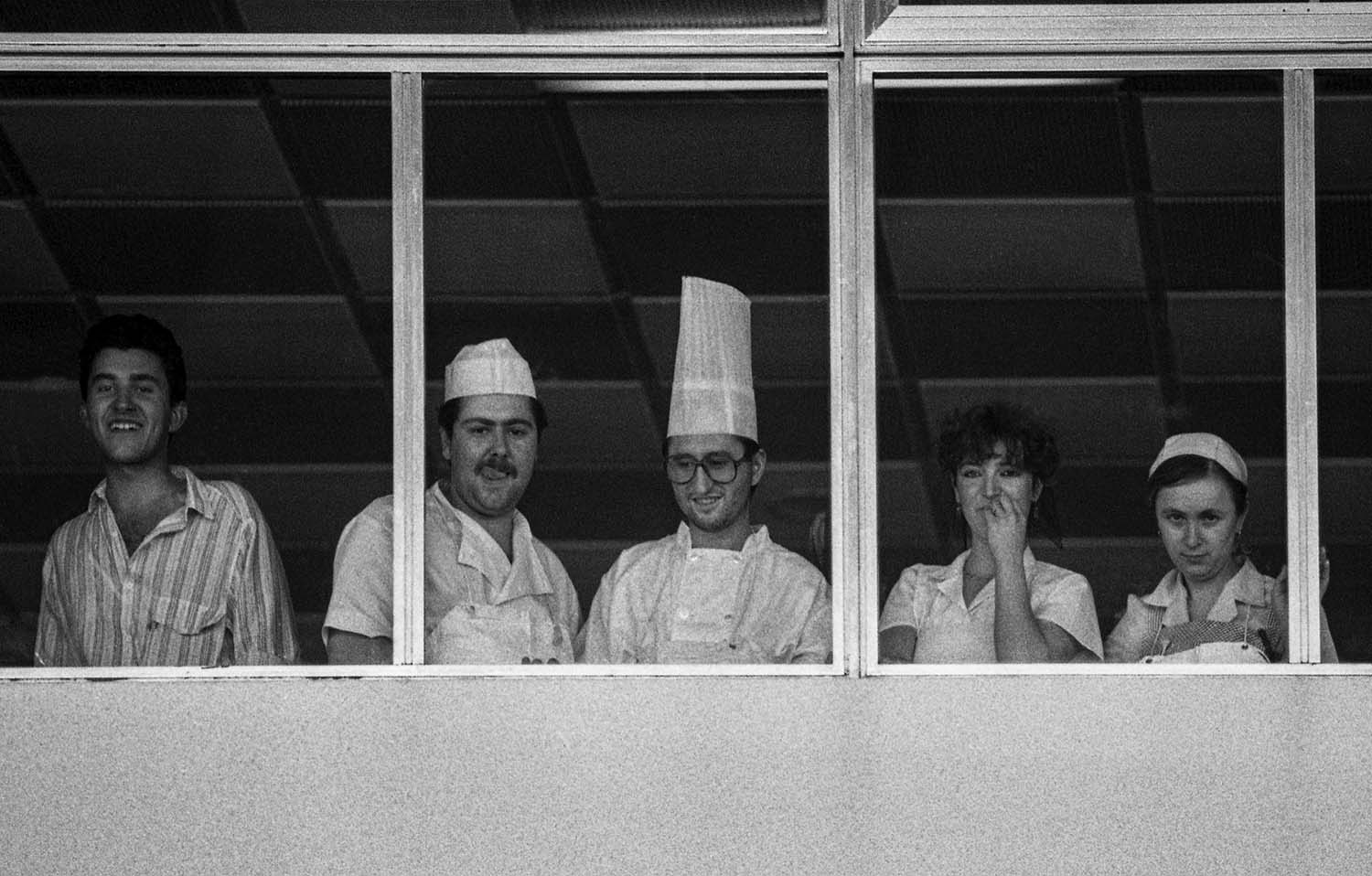 Diversos trabajadores del restaurante del aeropuerto del Prat mirando por la ventana la llegada de Cicciolina en 1987.