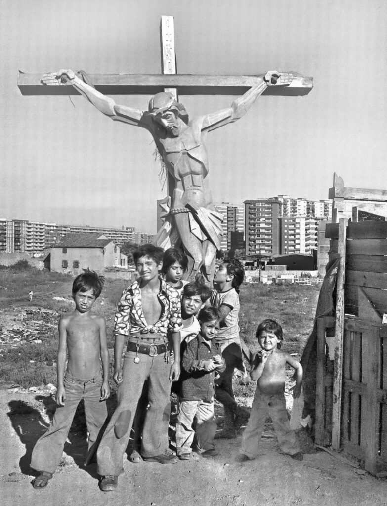 6 niños posan delante de un crucifijo de dos metros en un solar de La Perona